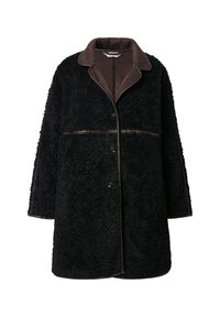Cappotto di peluche nero con colletto in suede marrone, chiusura a bottoni e tessuto esterno testurizzato. Maniche e orlo sono leggermente oversize.