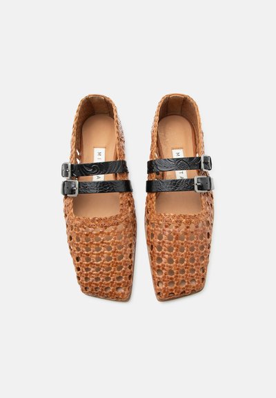 Ζευγάρι πλεγμένα καφέ δερμάτινα μπαλαρίνια με τετράγωνη μύτη και δύο μαύρες αγκράφες στο πάνω μέρος, εμφανισμένα από πάνω σε λευκό φόντο.