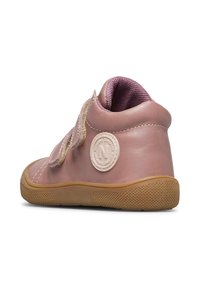 Scarpa alta in pelle rosa con suola in gomma testurizzata, fascia in Velcro e un'etichetta con logo circolare sul lato. Interno foderato in tessuto viola.