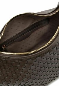 Sac en cuir tressé marron avec une fermeture éclair dorée, doté d'une doublure intérieure lisse et d'une poche zippée supplémentaire pour l'organisation.