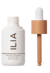 ILIA Super Serum Skin Tint SPF 30 i en vit flaska med bruna texter; har en brun pipett med en vit glödlampa. 1 fl oz (30 ml).