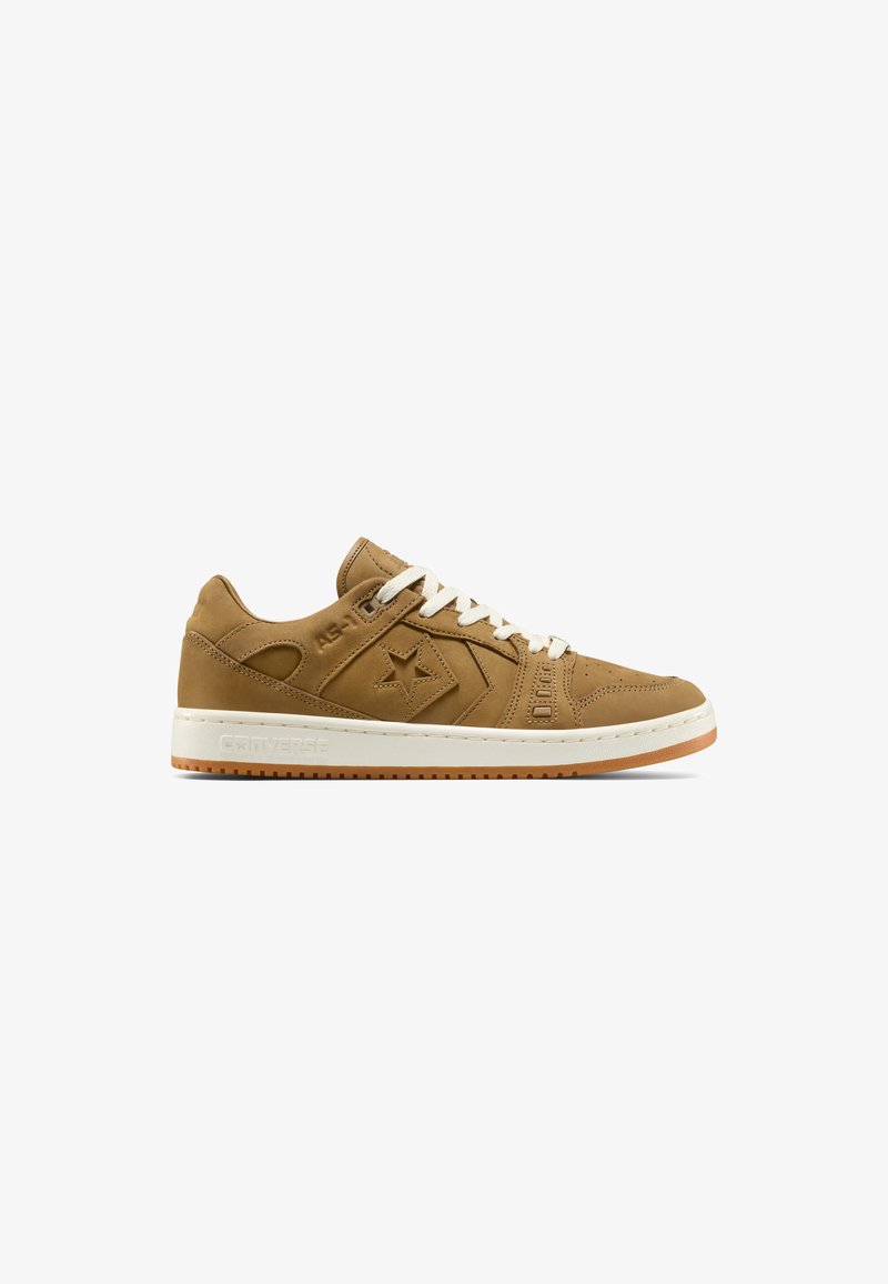Baskets Converse basses marron avec lacets blancs, logo étoile sur le côté et semelle blanche avec dessous couleur gomme.