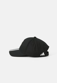 Casquette de baseball noire avec une visière incurvée, fabriquée en coton, dotée d'accents blancs à trois rayures et d'un logo à l'avant.