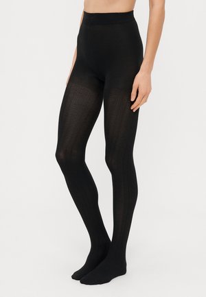 Leggings neri in maglia con vita alta, caratterizzati da un motivo testurizzato e un design aderente che si estende fino alla caviglia.