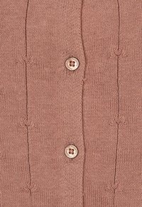 Stickad kofta i mjuk rosa, med ett ribbat mönster, dekorativt broderi och två träknappar med ingraverad logotyp.