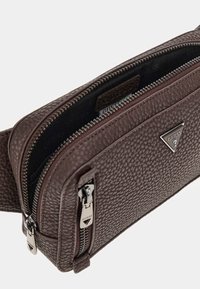 Braune, strukturierte Leder-Crossbody-Tasche mit doppelten Reißverschlüssen, ausgestattet mit einer metallischen Logo-Plakette und einem glatten Innenfutter. Kompakte und praktische Gestaltung.