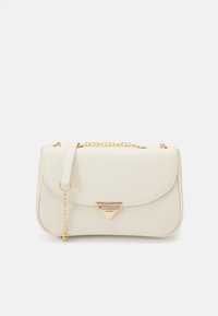 Tyylikäs kerma käsilaukku, jonka pinta on sileä, varustettu kolmiomaisilla kultaisilla metalliosilla ja irrotettavalla ketjuhihnalla. Laukussa on läppäkiinnitys ja pyöristetty muoto.