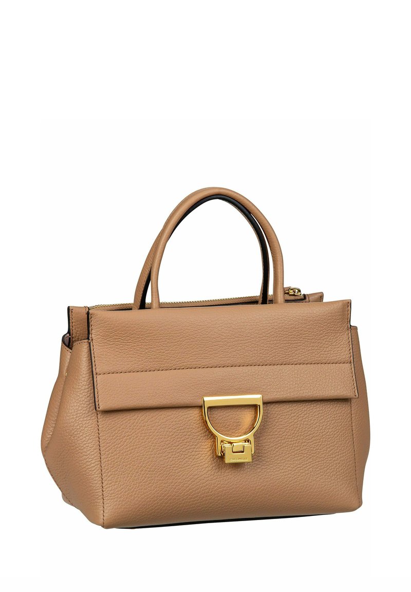 Sac à main en cuir beige avec finition texturée, doté de deux poignées, d'un rabat de fermeture et d'un détail de verrouillage accentué en or. Design compact et structuré.