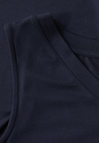 Mörkblått bomullstyg med en slät yta. V-ringad design med överlappande tygstycken, som har en ren sömdetalj.