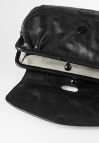 Borsa nera in pelle con finitura testurizzata, dotata di un interno in tessuto a righe, chiusura a scatto e un dettaglio decorativo a foro alla base.