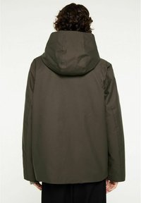 Olivgrön jacka med huva, med en något överdimensionerad passform, slät yta och utan synliga knäppningar eller förzieringar.