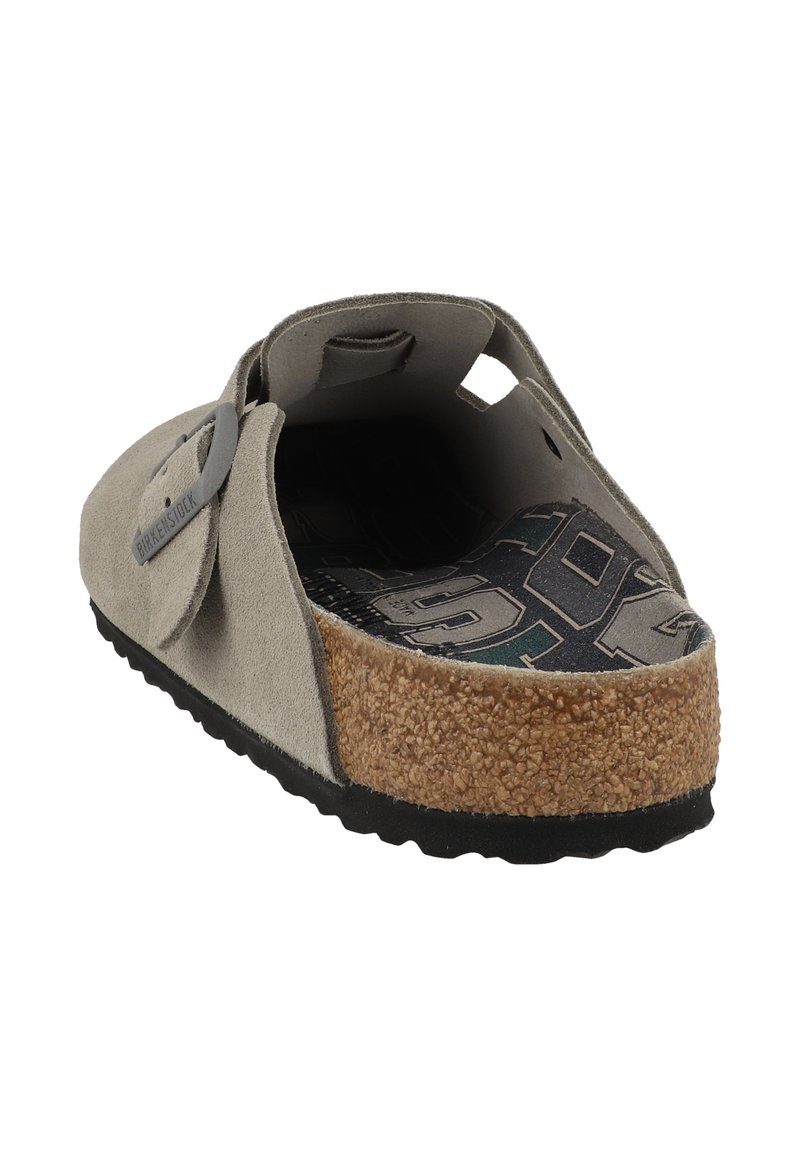 Gray suede slip-on sandal with a cork footbed, rubber outsole, and adjustable strap featuring a circular hardware detail.