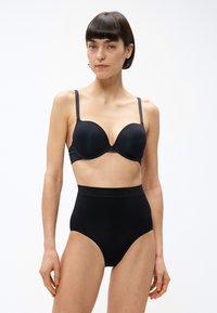 Sutien negru cu cupă modelată și bretele reglabile, asortat cu chiloți negri cu talie înaltă. Ambele sunt confecționate dintr-un material neted, cu cusături minime.