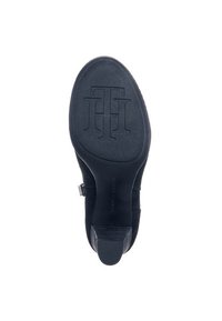 Sole černého vysokého podpatku s texturovaným gripem a vyvýšeným vzorem proplétaného "TH" loga v oblasti přední části.