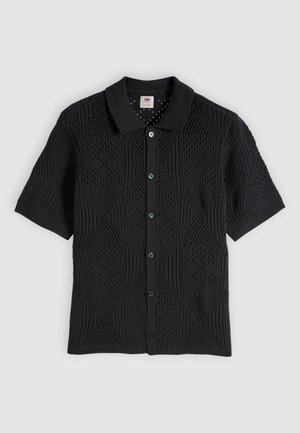 Schwarzes kurzärmliges Strickhemd mit Knöpfen, geometrischem offenen Strickmuster und geripptem Kragen, flach auf hellem Hintergrund dargestellt.