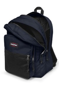 Navy modrá baťoh Eastpak vyrobený z odolné tkaniny, s více přihrádkami, zipy a síťovou přední kapsou pro úložný prostor.