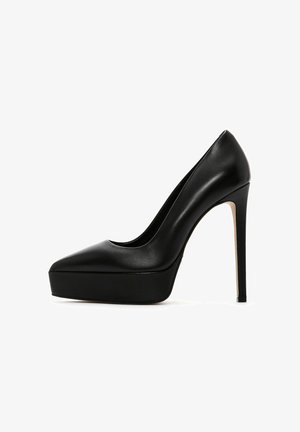 Chaussure noire en cuir à talons hauts avec un bout pointu, une semelle plateforme et un talon aiguille, présentant une texture lisse et un design élégant.