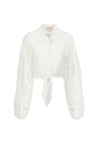 Camicia bianca cropped con maniche lunghe, caratterizzata da motivi floreali intagliati, chiusura con lacci frontale e colletto a punta. Tessuto morbido e leggero.