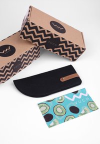 Černá plstěná pouzdro na tužky s koženým akcentem. Dvě hnědé kartonové krabičky s cik-cak vzorem a logem "VUCH". Barevná karta s designem kiwi.