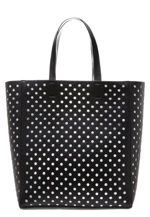 Sac cabas noir avec deux poignées et un motif de trous blancs ronds espacés uniformément couvrant sa surface.