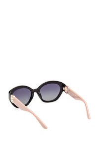 Gafas de sol estilo cat-eye en color negro con lentes de degradado, patillas en color rosa claro y detalles metálicos en las bisagras. El material de plástico suave contrasta con los acentos brillantes.