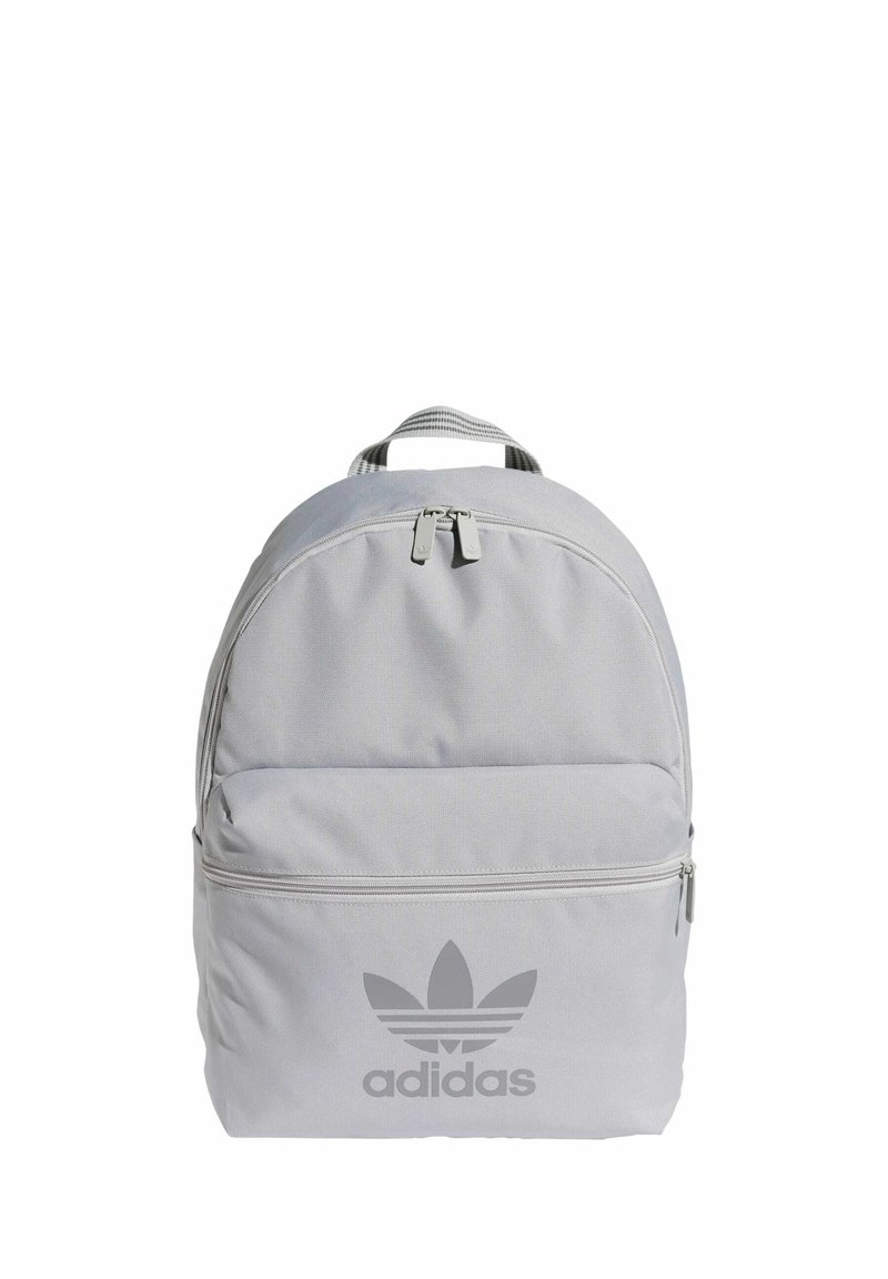 Sivi platneni ruksak s dvostrukim zatvaračem, prednjim džepom i velikim Adidas logotipom u tamnijoj sivoj boji. Ima zaobljen oblik i podstavljenu ručku na vrhu.