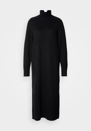 Mustmustritud must kleit kõrge kaelusega, pikkade varrukatega ja soonikkudumisega mansetid. Omab sirget siluetti ja külgmisi lõhesid hempluusis.