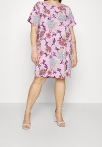 Šaty s květinovým potiskem v světle růžové barvě, krátké rukávy, volný střih, s různobarevnými květinovými vzory na texturovaném pozadí.