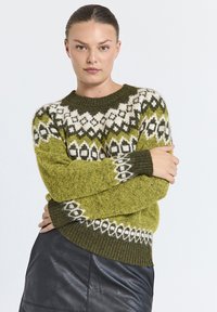 Stickad tröja i grönt och krämfärgat med ett geometriskt mönster, rundad halsringning och ribbade ärmslut. Designad med en avslappnad passform.