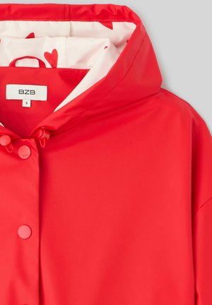 Veste imperméable rouge avec capuche, dotée de boutons et d'une doublure décorée de cœurs rouges sur fond blanc. Taille S.