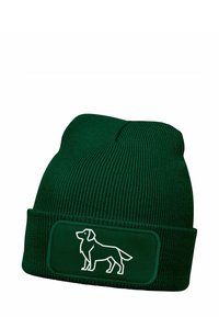 Green knitted beanie with a folded cuff, featuring a white outline of a dog on a rectangular patch. Soft texture, ribbed design.