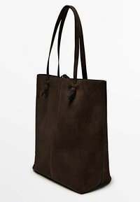 Sac fourre-tout en daim marron avec deux longues anses, présentant une texture lisse, un design minimaliste et deux liens réglables à l'avant.