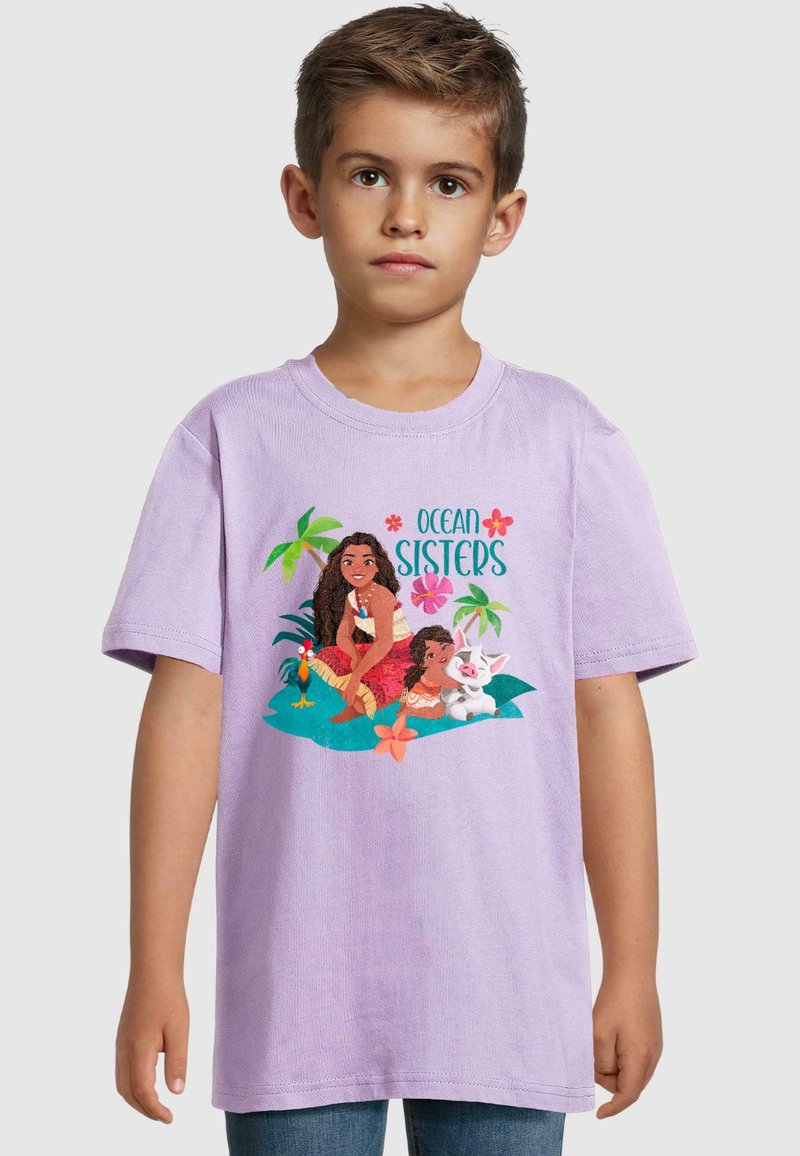 Lavendel bomull t-skjorte med en illustrasjon av to animerte karakterer omgitt av tropiske elementer, med teksten "OCEAN SISTERS" i blått.