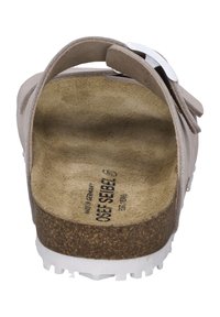 Sandal in beige chiaro con cinturini regolabili, soletta in sughero, suola in gomma bianca e un dettaglio in fibbia argentata sul cinturino superiore.