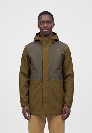 Man wearing a two-tone olive green North Face hooded jacket with front zipper and elastic cuffs, standing against a plain white background.