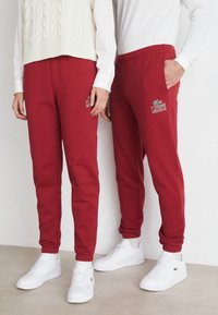 Lacoste - SUBTLE LOGO TRACKPANT UNISEX  - Verryttelyhousut - ora Pienoiskuva 1