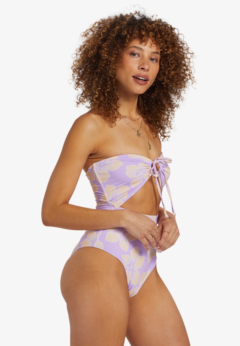 Bikini floral violet avec un haut sans bretelles présentant un détail à nouer et un bas taille haute. Tissu lisse et extensible avec des accents pastel.