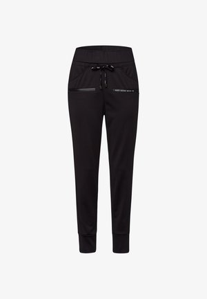 Black tapered jogger pants with elastic waistband, drawstring, zippered front pockets, and "KEEP GOING MOVE ON" text on right pocket.