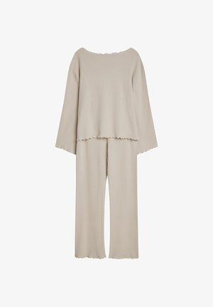 Jasnobeżowy zestaw odzieży domowej składający się z bluzki z długim rękawem o falbaniastym dekolcie oraz pasujących spodni z szerokimi nogawkami, również z falbaniastym wykończeniem.