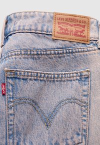 Υφασμα από ανοιχτό μπλε τζιν με πίσω τσέπη που διαθέτει κλασικό σχέδιο σε σχήμα V. Καφέ δερμάτινη ετικέτα με το λογότυπο της μάρκας στη μέση του παντελονιού.