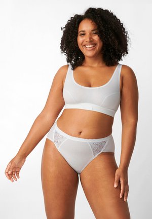 Completo di biancheria intima grigio chiaro con un bralette senza cuciture e spalline larghe, abbinato a un brief a vita alta con dettagli in pizzo.