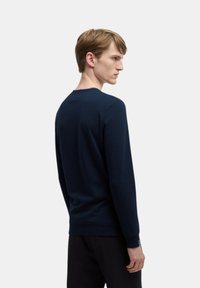 Maglione blu navy con maniche lunghe, polsini e orlo a coste, scollatura a girocollo e texture liscia, visto dal retro.