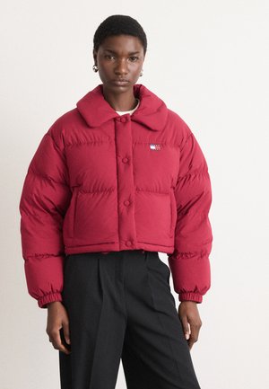 Rød cropped pufferjakke med stor krave, trykknapper og forlommer; har et lille logo-patch på venstre bryst.