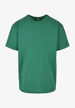 Zöld pamut póló klasszikus kerek nyakkal, rövid ujjakkal és laza fazonnal; sima textúrájú, minta vagy díszítés nélkül.