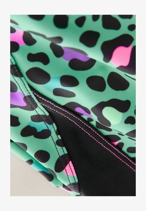 Zielona tkanina w czarną, różową i fioletową wzór lamparta. Charakteryzuje się kontrastowym czarnym przeszyciem wzdłuż szwu, gładką teksturą.