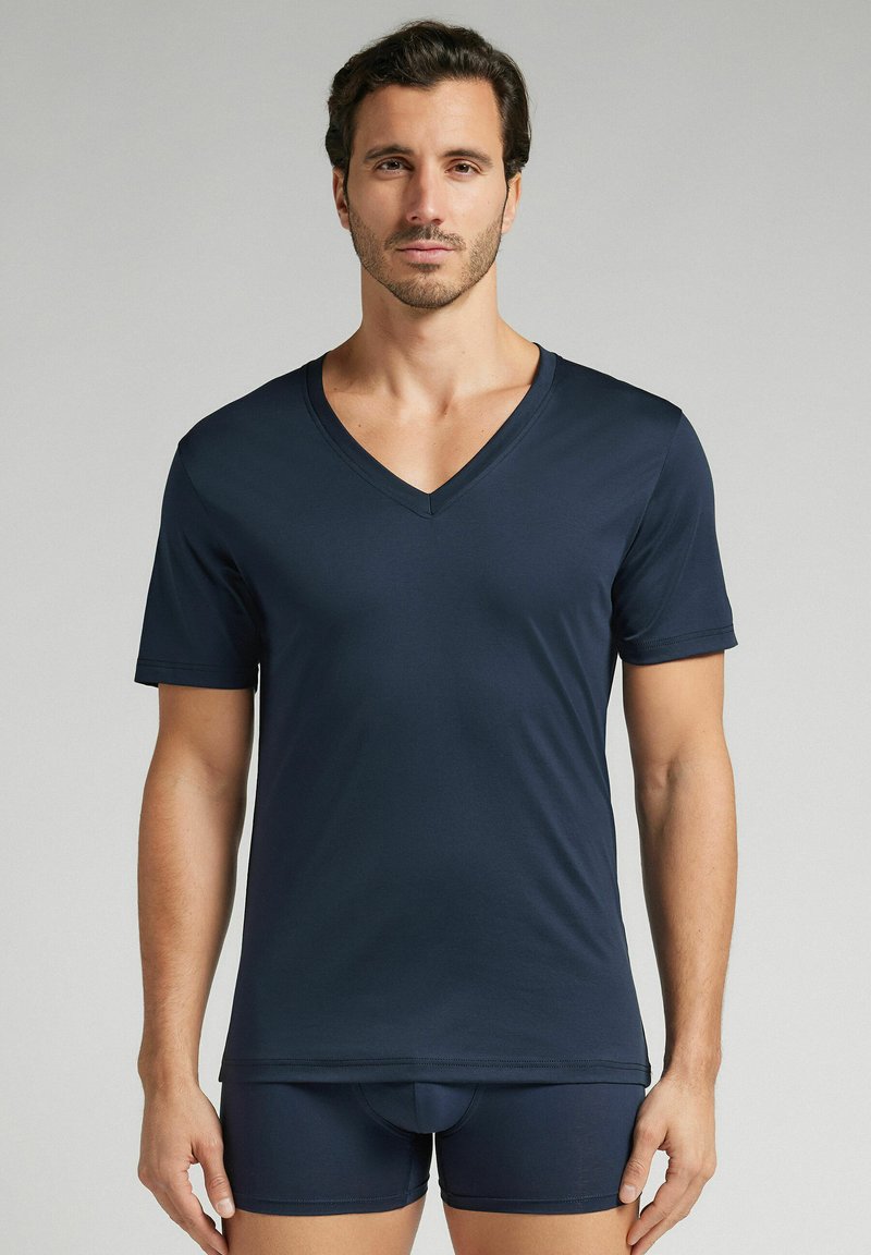 Granatowa koszulka typu V-neck z krótkim rękawem wykonana z gładkiego, lekkiego materiału, w zestawie z dopasowanymi bokserkami, prezentująca prosty design.