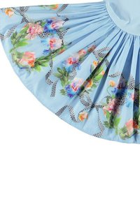 Vaaleansininen mekko, jossa on levenevä hame, kukkakuosilla, jossa on vaaleanpunaisia, oransseja ja sinisiä värejä, ja musta-valkoiset ruudulliset nauhat korostavat kokonaisuutta.