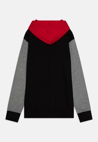 Felpa con cappuccio con cappuccio rosso, corpo nero e maniche grigie. Realizzata in tessuto morbido, con vestibilità standard e polsini a costine.