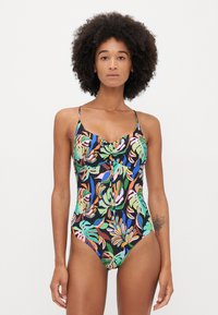 One-piece swimsuit in black with a colorful tropical leaf pattern. Features adjustable straps and a gathered front detail.