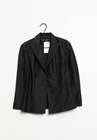 Svart blazer i slät tyg med spetsig krage, enkel knäppning och långa ärmar. Hänger på en svart krok.